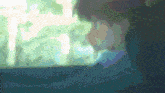 a blurry picture of a person looking out a window with trees in the background