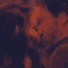 a man and a woman are kissing each other in a dark room .