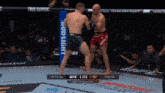 two men are fighting in a boxing ring with a bud light banner in the background