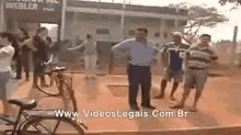 a group of people standing in front of a building with the website www.videoslegais.com.br on the bottom