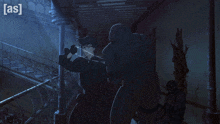 a man is hanging from a rope in a dark room with the letters as on the bottom right