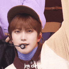 a close up of a person wearing a hat and a microphone with the word jm devil on the bottom right