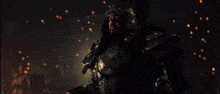 a man in armor is holding a torch and another man is standing behind him