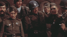 a group of soldiers are standing around a man in a helmet with a star on his chest