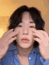 a close up of a person 's face with their hands on their face
