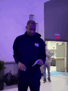 a man in a black hoodie with the letter r on the front