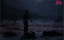 a man standing on a bloody beach with the letters xhk above him
