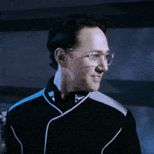 a close up of a man wearing glasses and a black shirt