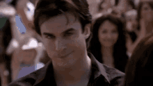 a man in a black shirt is smiling in front of a crowd