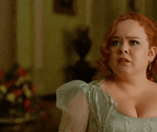 a woman with red hair is wearing a blue top