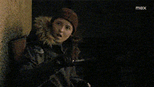 a girl is holding a flashlight and making a funny face .