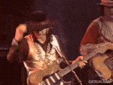 a man in a cowboy hat is playing a guitar and singing into a microphone