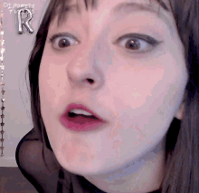 a close up of a woman 's face with the letter r written on it