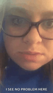 a close up of a woman wearing glasses with the words `` i see no problem here '' .