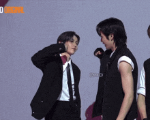 a man in a suit and tie stands next to another man in a white shirt with a ctrl + v sticker
