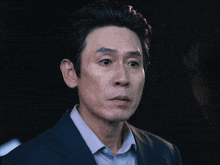 a man with a surprised look on his face is wearing a suit