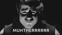 a black and white photo of a man with a shadow on his face and the words `` muhtherrrr '' written above him .