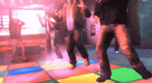 a group of people are dancing on a colorful dance floor with yeardev diamond written on the bottom right