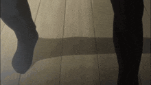 a person wearing black socks is standing on a wood floor