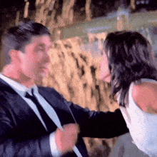 a man in a suit and tie kisses a woman on the cheek