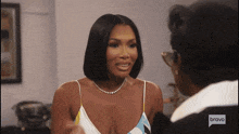 a woman wearing a necklace is talking to another woman on bravo television