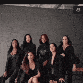 a group of women are posing for a picture and one of them is sitting on a bench