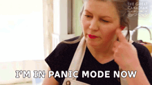 a woman in an apron is saying " i 'm in panic mode now " .