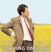 mr bean is standing in a field with his hands on his hips .