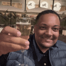 a man holds up a glass of champagne in front of a sign that says ' wtc ' on it