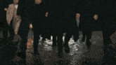a group of people wearing suits and hats are walking
