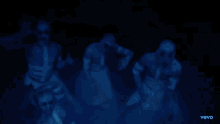 a group of people are dancing in a dark room with the word vevo on the bottom right