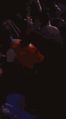 a crowd of people are gathered around a red object
