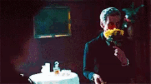 a man in a tuxedo holds a rose in his mouth
