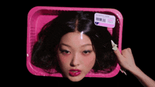 a woman 's head is in a pink plastic container with a label that says all natural foods
