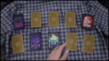 a person is playing with tarot cards on a checkered table cloth