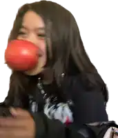 a girl wearing a black shirt that says ' nirvana ' on it chews an apple