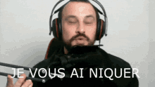 a man wearing headphones with the words je vous ai niquer written below him