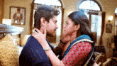 a man and a woman are kissing in a room