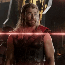 a man with long hair and a beard wearing a leather vest