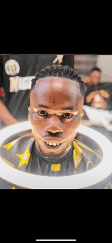 a man is getting his hair cut by a barber wearing a shirt that says nice