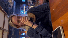 a woman is sitting at a table drinking a glass of beer
