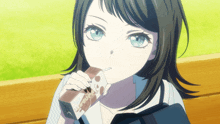 a girl with blue eyes is eating a chocolate bar with a cat on it