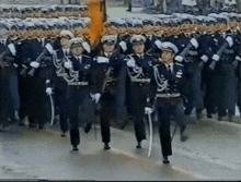 a group of soldiers marching down a street holding swords