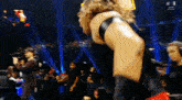 a man in a black tank top is standing on a stage .