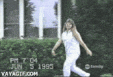 a woman in white pants is dancing in front of a building on june 5 1995