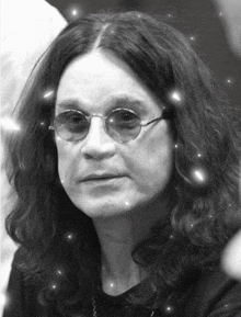 a black and white photo of a man with long hair and sunglasses