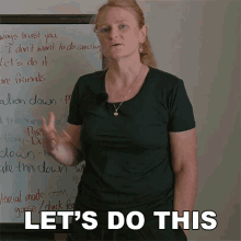 a woman is standing in front of a white board with the words let 's do this written on it