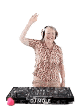 a woman wearing headphones is standing in front of a dj mole machine