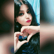 a woman is making a heart shape with her hands and the word you is on her shirt