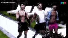 a group of men are walking down a runway with the hashtag gran hermano on the bottom of the screen .